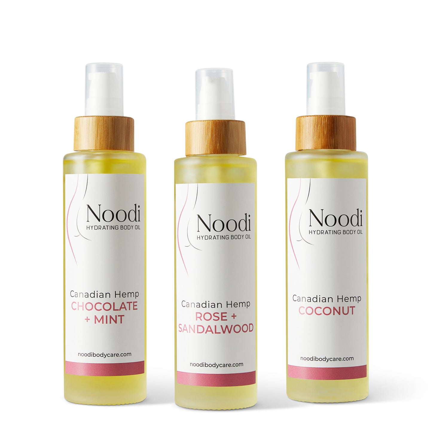 Three bottles of Noodi Hydrating Body Oil in flavors: Chocolate + Mint, Rose + Sandalwood, and Coconut, with wooden caps.